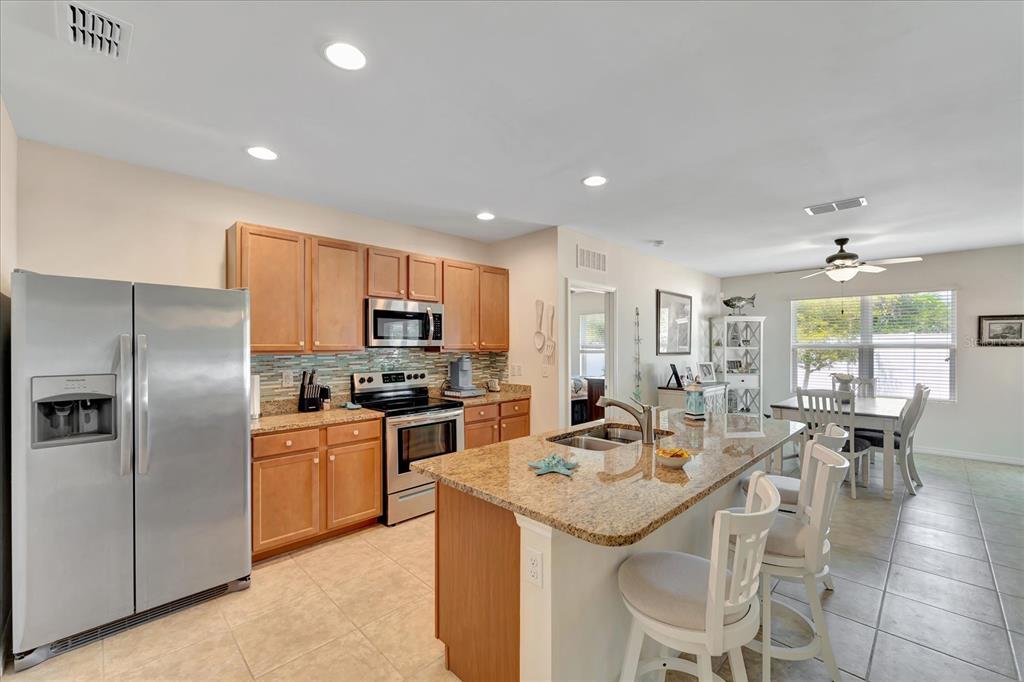 8997 Excelsior Loop Venice, FL 34293 - Photo 24 of 48 a kitchen with stainless steel appliances kitchen island granite countertop a sink and cabinets