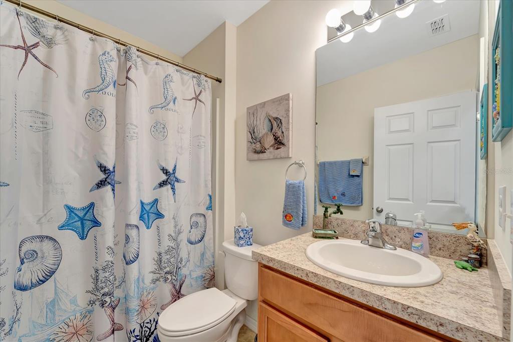 8997 Excelsior Loop Venice, FL 34293 - Photo 27 of 48 a bathroom with a granite countertop sink toilet a mirror and shower curtain