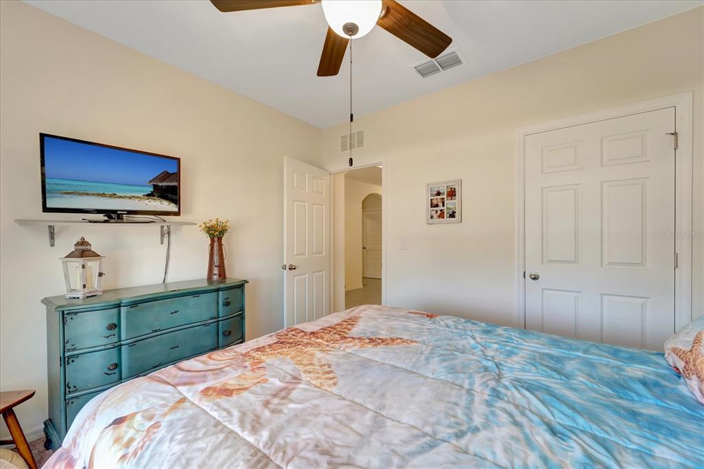 8997 Excelsior Loop Venice, FL 34293 - Photo 34 of 48 a bedroom with a bed and a flat tv screen on dresser