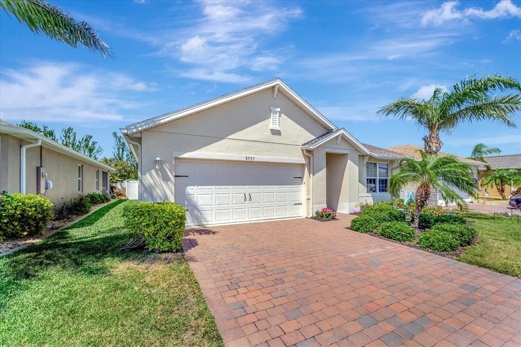 8997 Excelsior Loop Venice, FL 34293 - Photo 47 of 48 a front view of a house with a yard and potted plants
