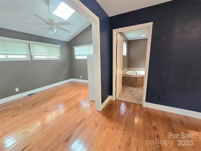 a view of a room with wooden floor and a bathroom