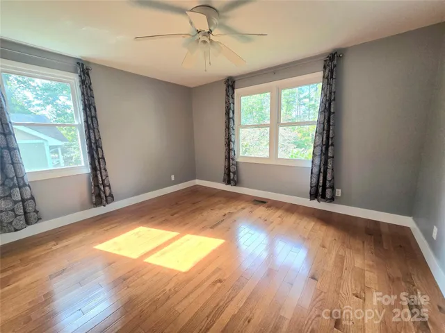 a view of a room with wooden floor and windows