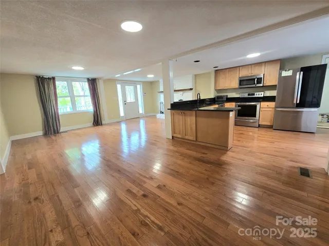a view of kitchen with sink and refrigerator