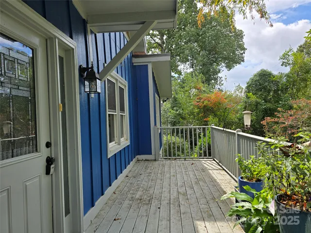 a balcony with wooden floor and stairs