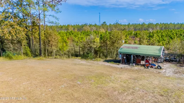 a view of a swimming pool with outdoor seating and covered with trees