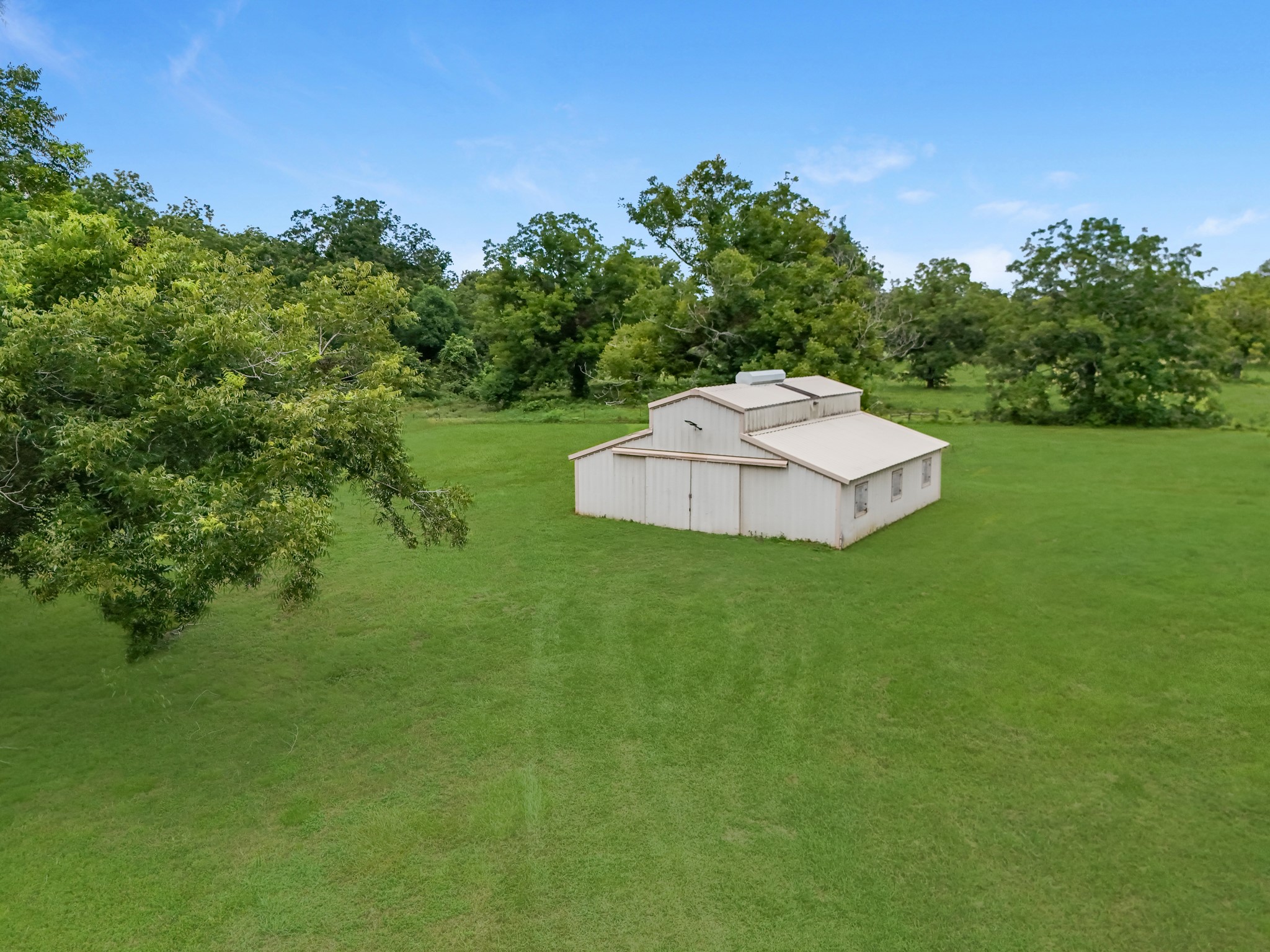 17126 County Road 39 Rosharon, TX 77583 - Photo 43 of 47 Another view of the barn and vast pasture area. Hard to see but there is a raised packed surface roadway under the grass for easy access.