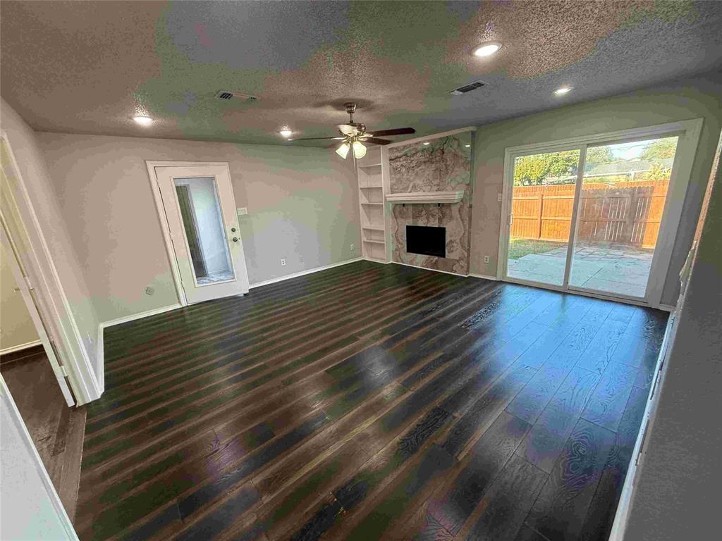 2959 Scott Mill Road Carrollton, TX 75007 - Photo 5 of 26 an empty room with wooden floor and fireplace