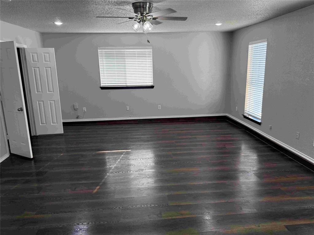 2959 Scott Mill Road Carrollton, TX 75007 - Photo 10 of 26 an empty room with wooden floor chandelier fan and windows
