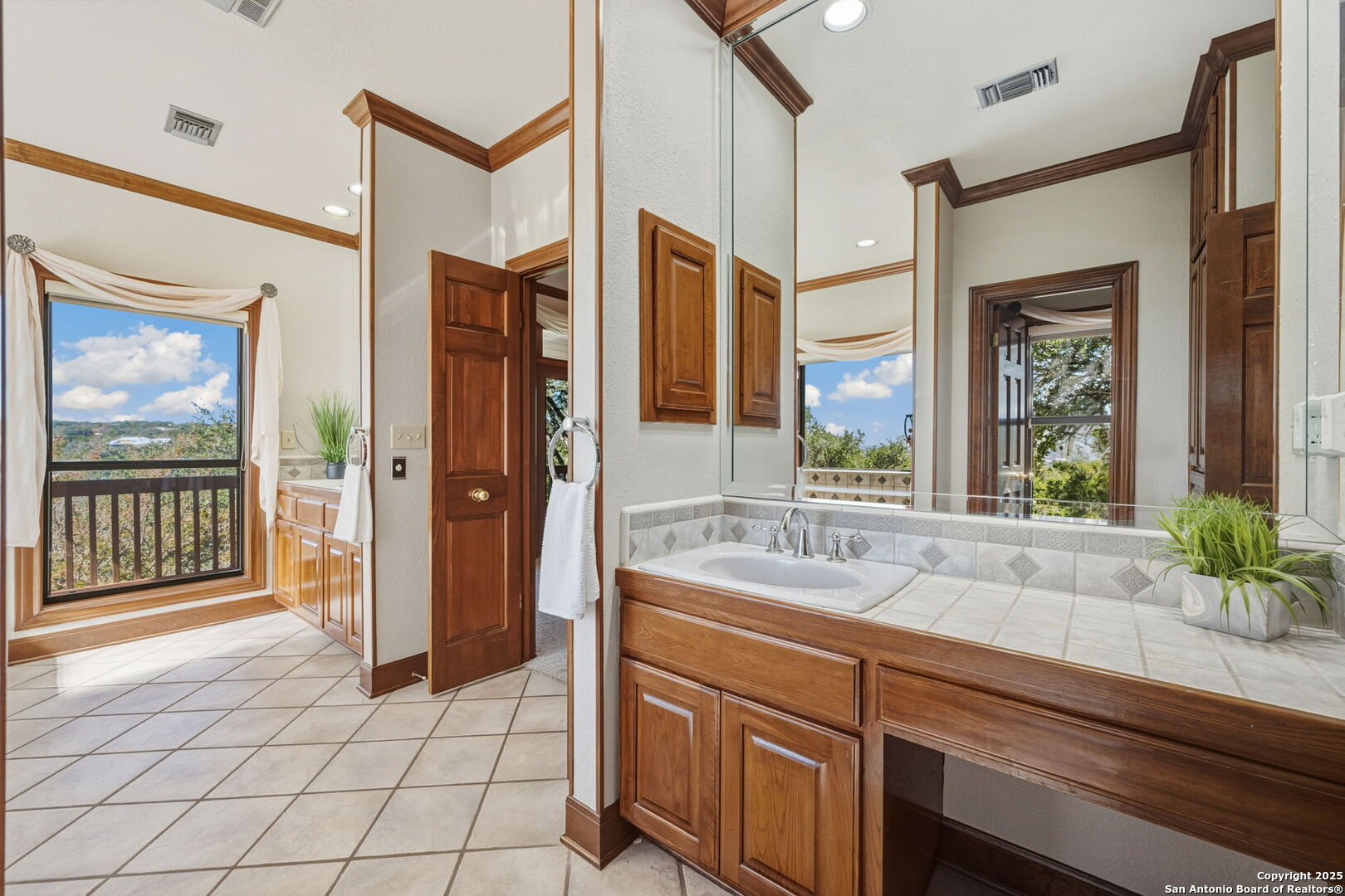 14819 Seven L Trail Helotes, TX 78023 - Photo 14 of 61 a spacious bathroom with a granite countertop sink a mirror a and a shower