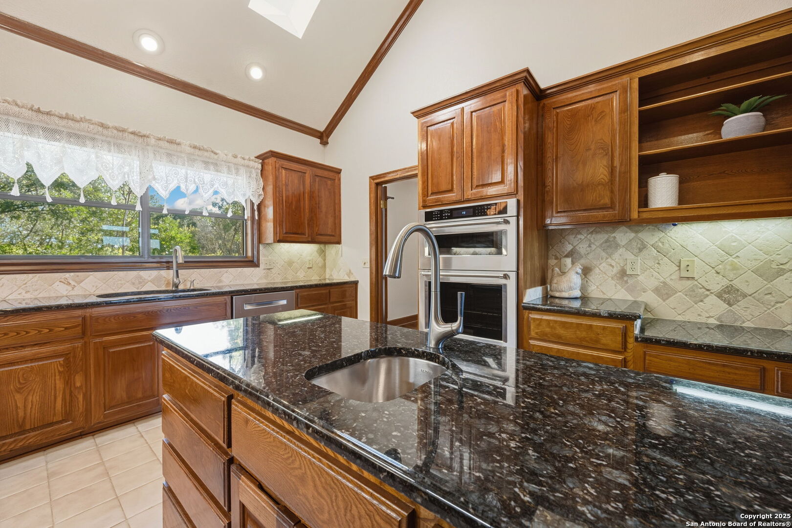 14819 Seven L Trail Helotes, TX 78023 - Photo 22 of 61 a kitchen with stainless steel appliances granite countertop a sink a stove and a microwave