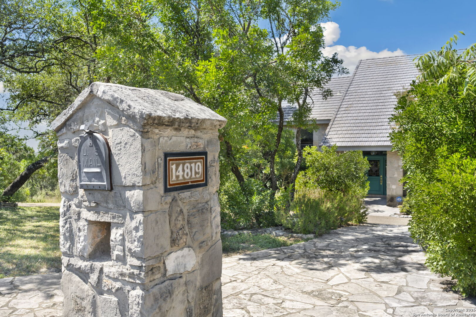 14819 Seven L Trail Helotes, TX 78023 - Photo 38 of 61 a view of a stone house with a fountain