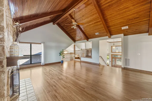 a view of an room with wooden floor fan and windows