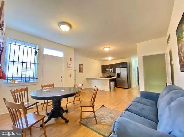 a living room with furniture two window and a dining table