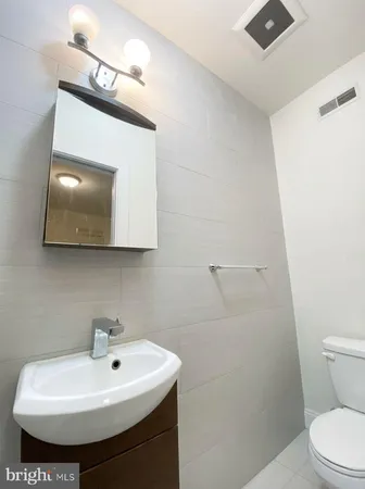 a bathroom with a sink toilet and mirror