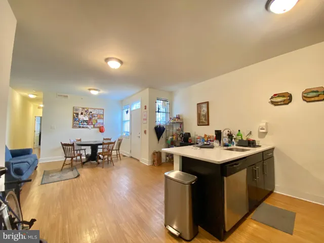 a view of a kitchen with kitchen island a sink a table and chairs in it