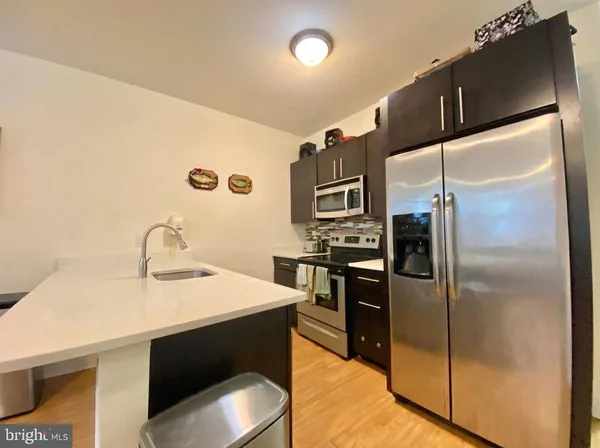a kitchen with a sink refrigerator and microwave