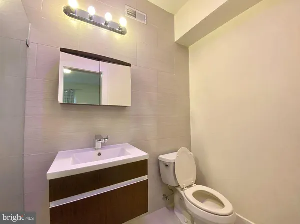 a bathroom with a sink mirror and toilet