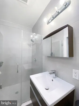 a bathroom with a sink a shower and a mirror