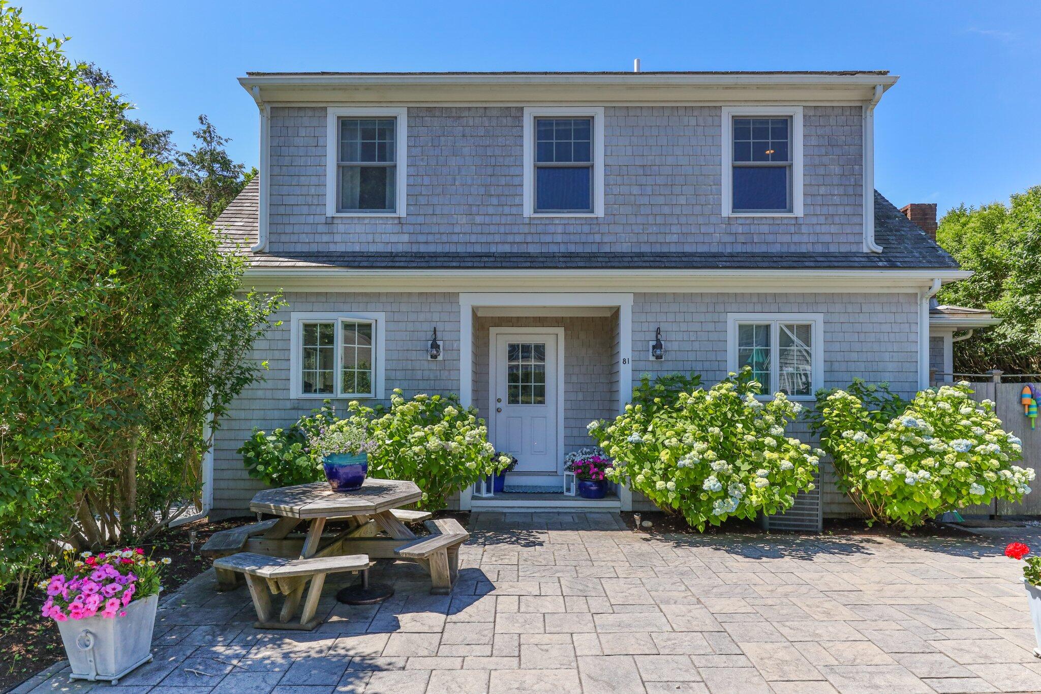 81 Mill Pond Road Chatham, MA 02633 - Photo 35 of 59 a front view of a house with lots of potted plants