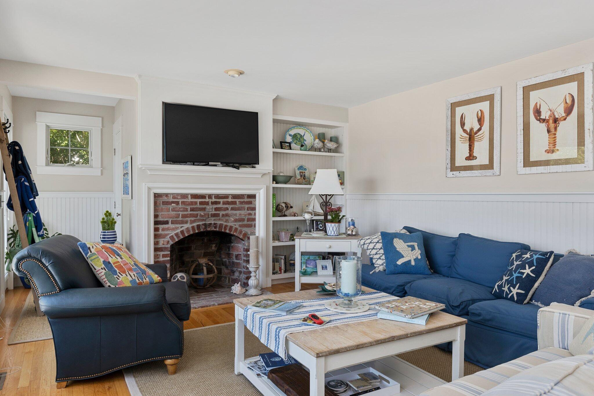 81 Mill Pond Road Chatham, MA 02633 - Photo 6 of 59 a living room with furniture flat screen tv and a fireplace