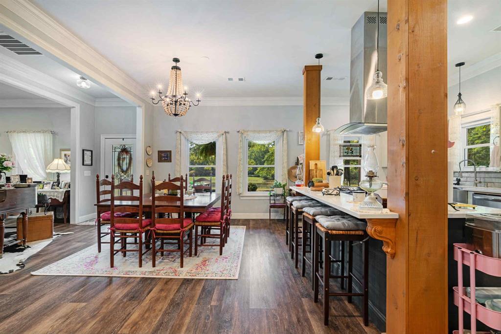 2205 County Road Blossom, TX 75416 - Photo 9 of 27 Dining area with ornamental molding, dark wood-type flooring, healthy amount of natural light, and a chandelier