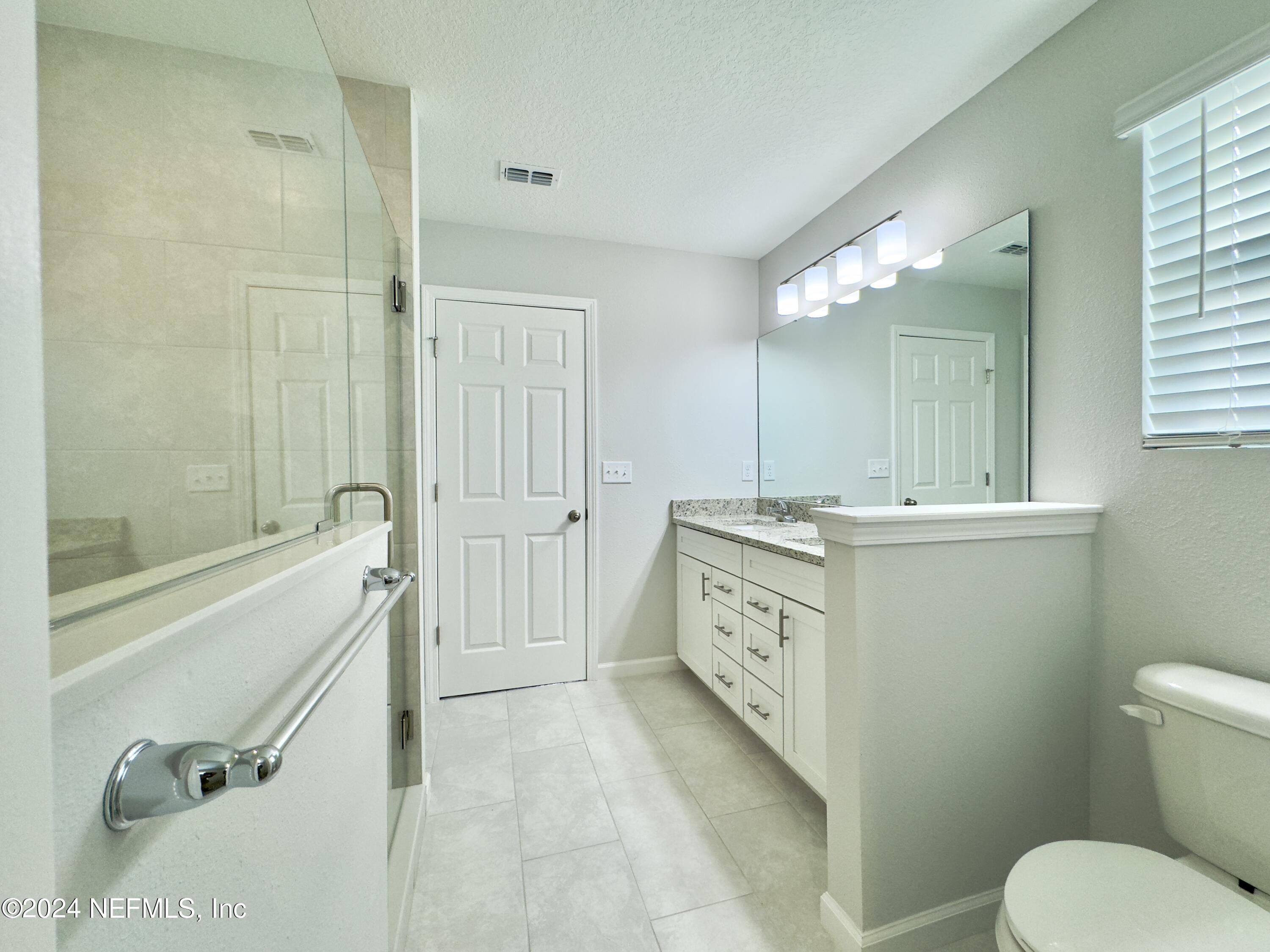 4672 Ribault Park Street Jacksonville, FL 32233 - Photo 14 of 22 a bathroom with a granite countertop sink a toilet and shower