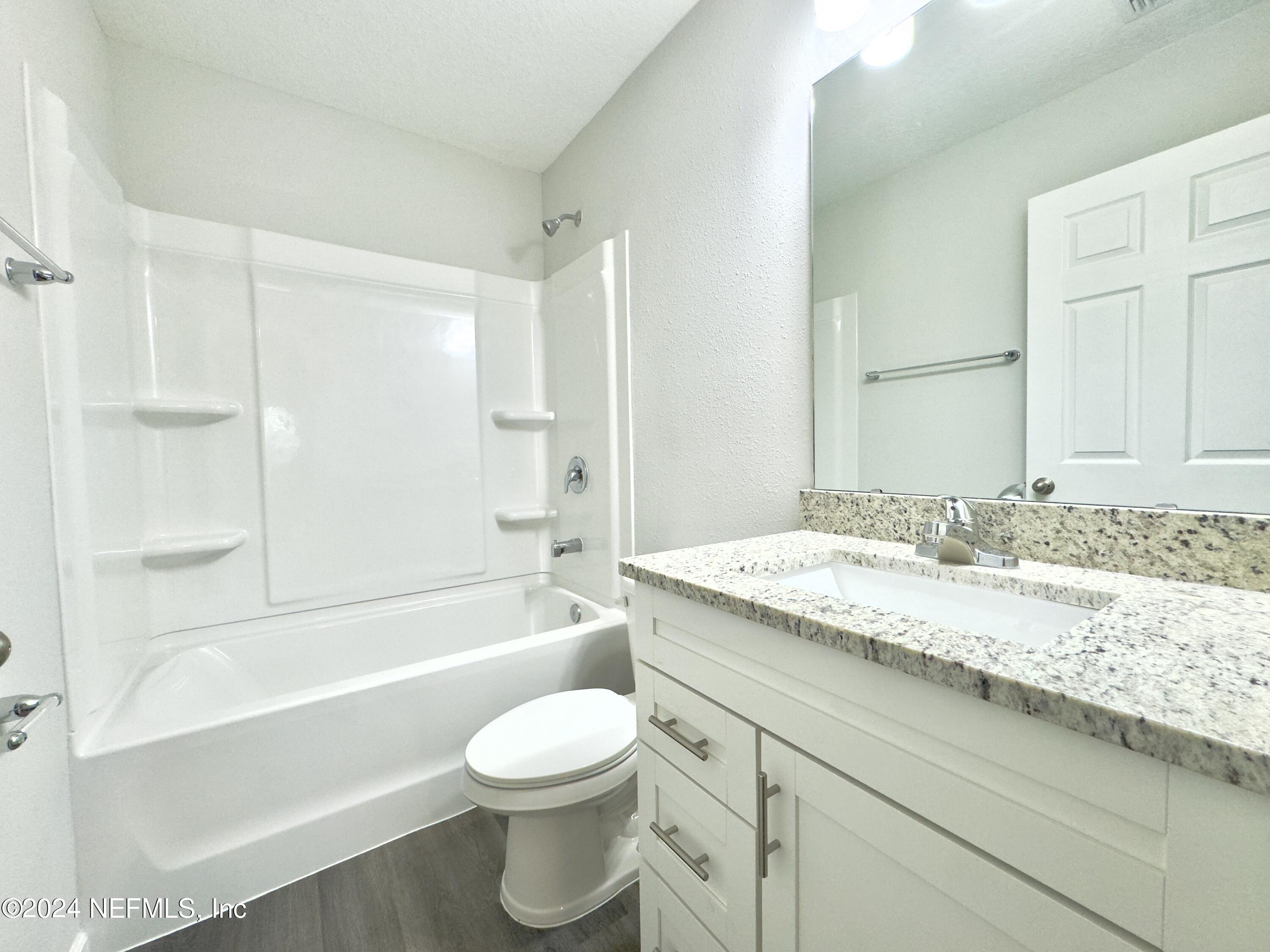 4672 Ribault Park Street Jacksonville, FL 32233 - Photo 17 of 22 a bathroom with a granite countertop sink a toilet and bathtub
