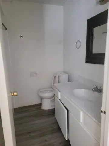 a bathroom with a granite countertop toilet sink and mirror