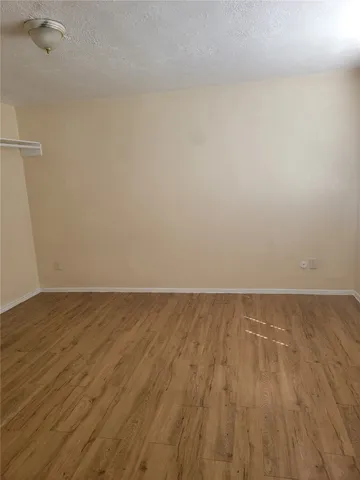 a view of an empty room and wooden floor