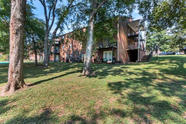 a view of a house with a yard and tree s