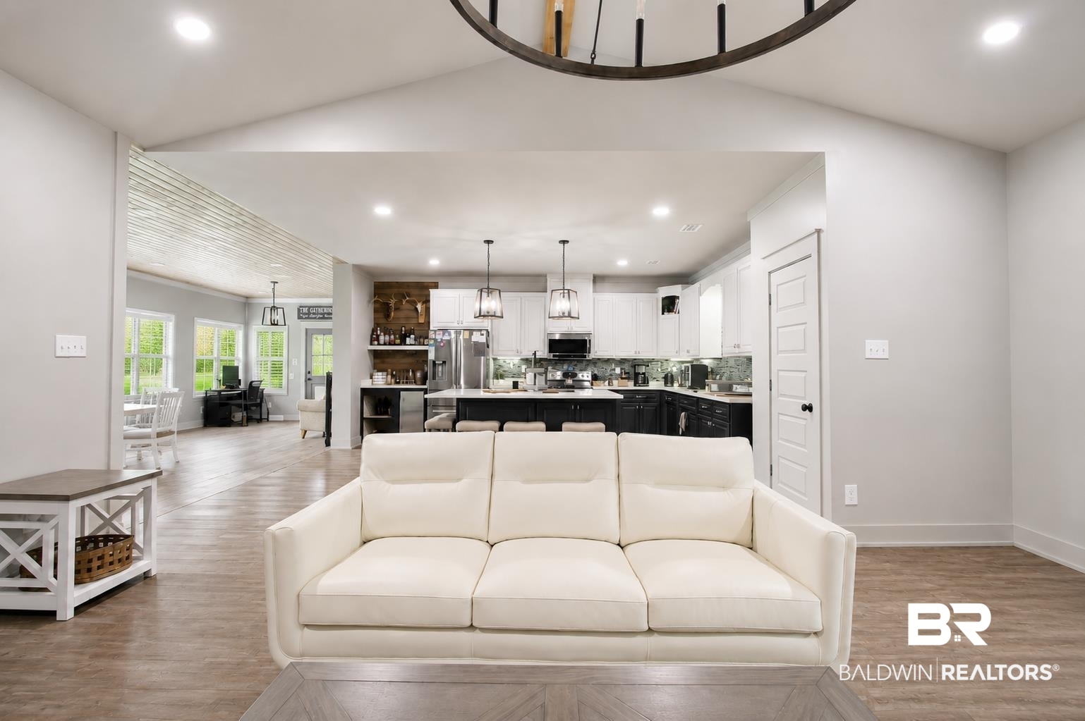 9825 Wolf Creek Ridge Elberta, AL 36530 - Photo 41 of 76 Open-concept interior featuring wood-finish flooring, vaulted ceilings, recessed lighting, and a kitchen with two-tone cabinetry and pendant lighting