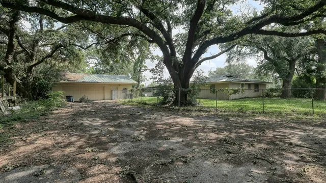 a view of house with a trees front of the house