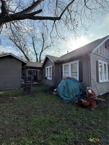 a view of a house with a backyard space and a tree