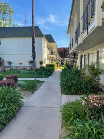 a front view of a house with a yard and potted plants