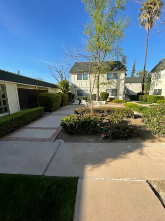 a view of a house with a yard and potted plants