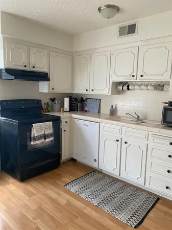 a kitchen with stainless steel appliances granite countertop a sink stove and cabinets