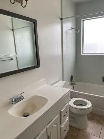 a bathroom with a sink a toilet and a mirror