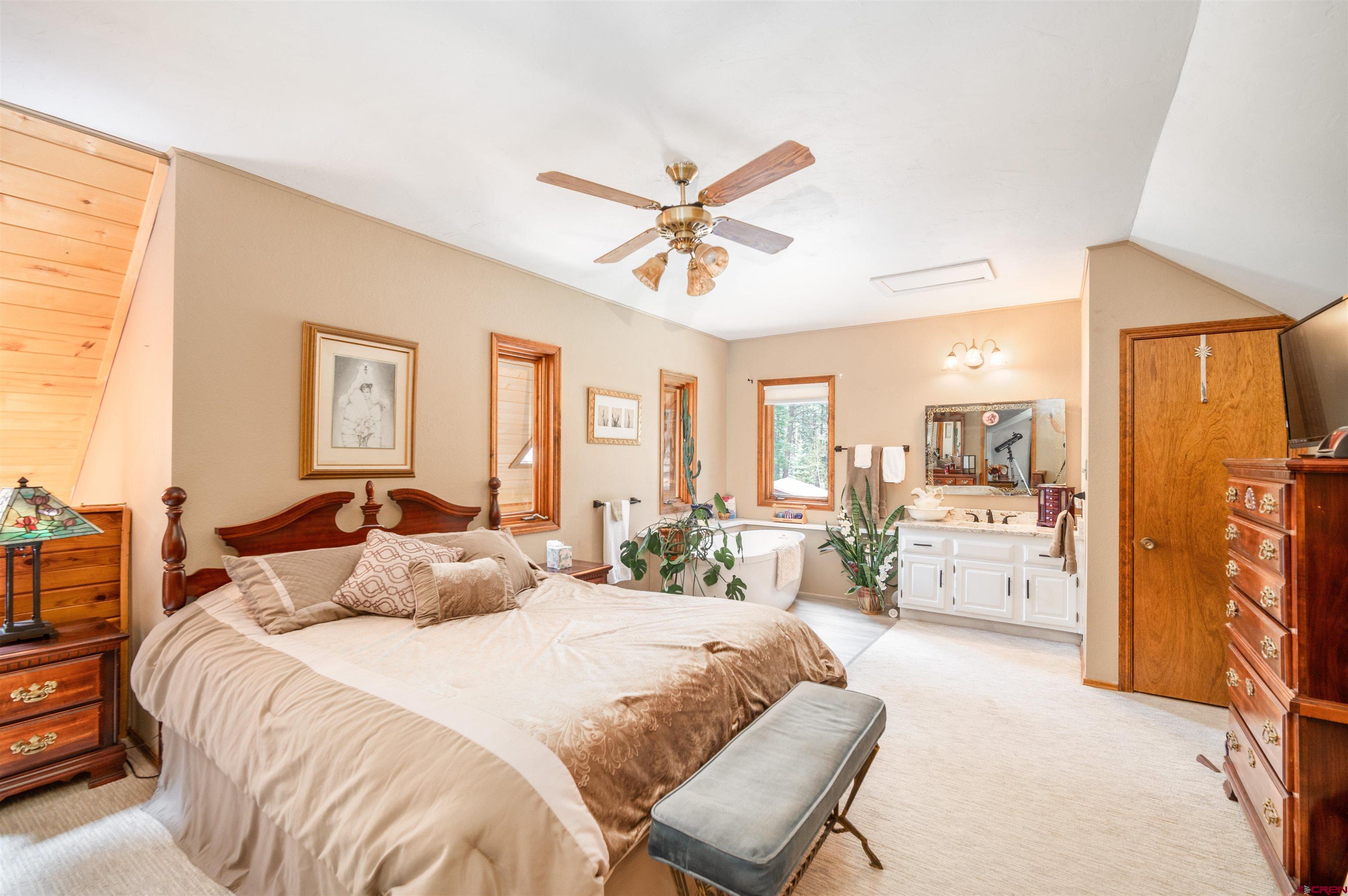 520 Los Ranchitos Drive Durango, CO 81301 - Photo 19 of 36 a bedroom with a bed a chandelier and dresser
