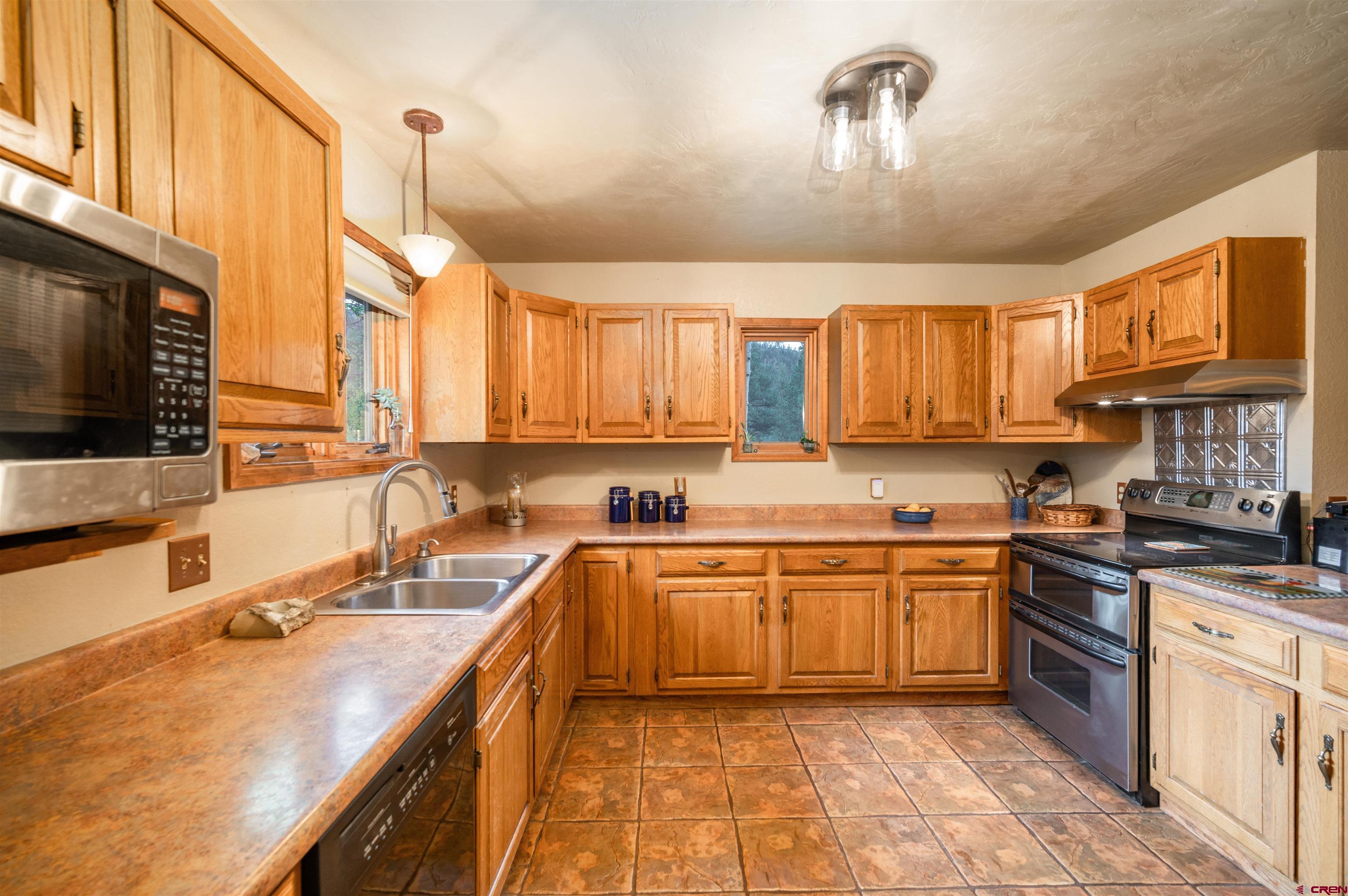 520 Los Ranchitos Drive Durango, CO 81301 - Photo 8 of 36 a kitchen with stainless steel appliances granite countertop a sink a stove and a wooden cabinets