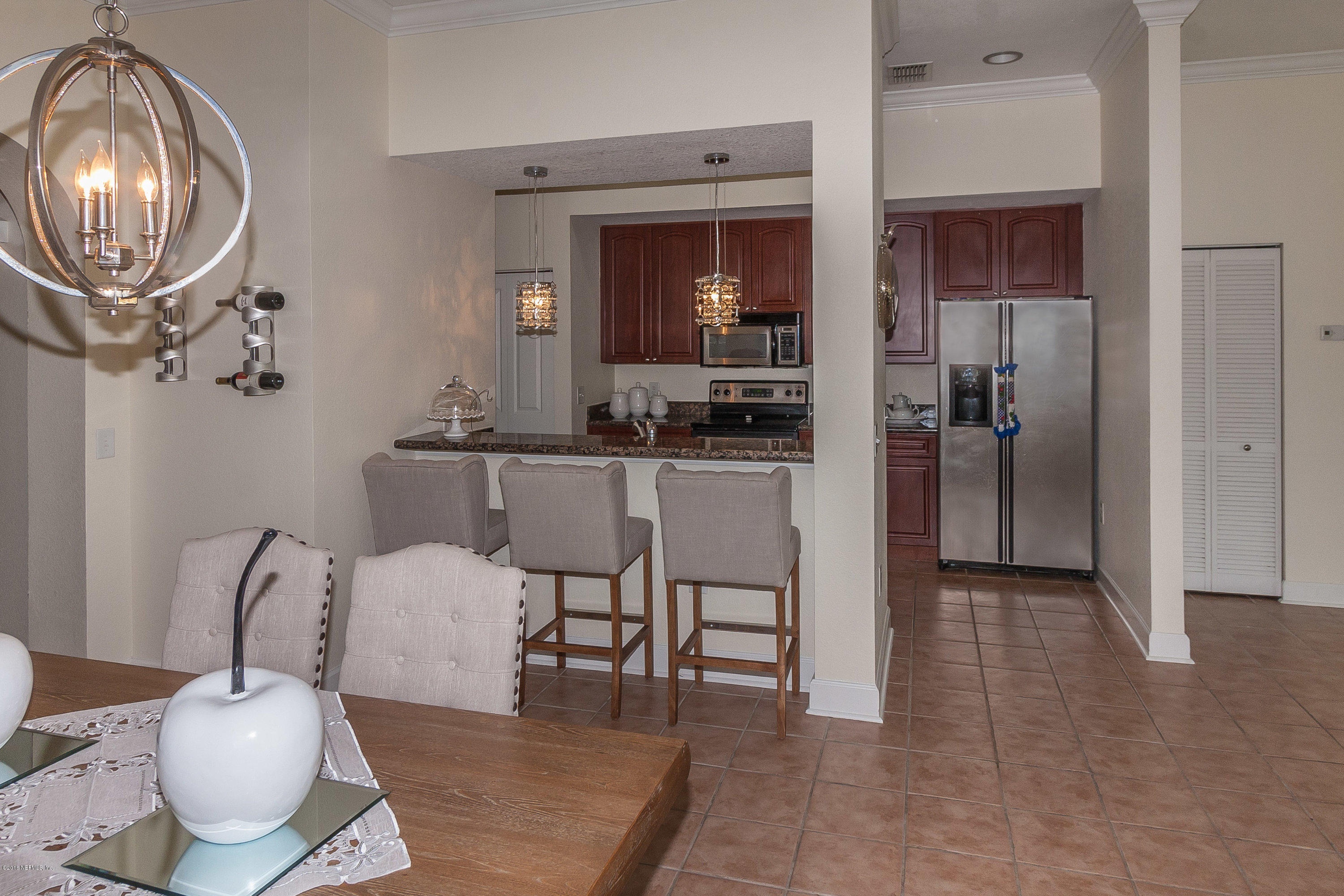 9745 Touchton Road, Unit 2521 Jacksonville, FL 32246 - Photo 11 of 31 a dining room with furniture a rug and a chandelier