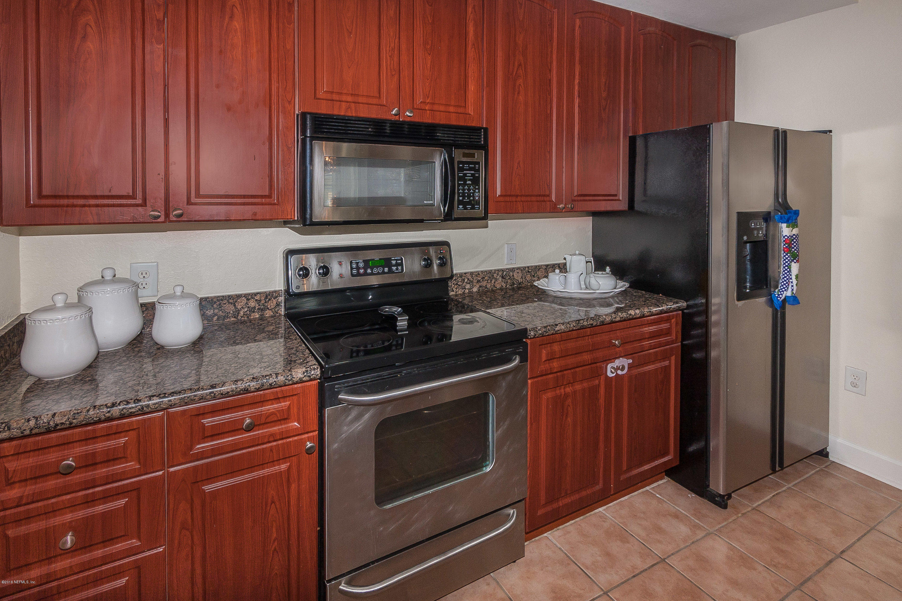 9745 Touchton Road, Unit 2521 Jacksonville, FL 32246 - Photo 9 of 31 a kitchen with granite countertop stainless steel appliances a stove a microwave a sink and cabinets