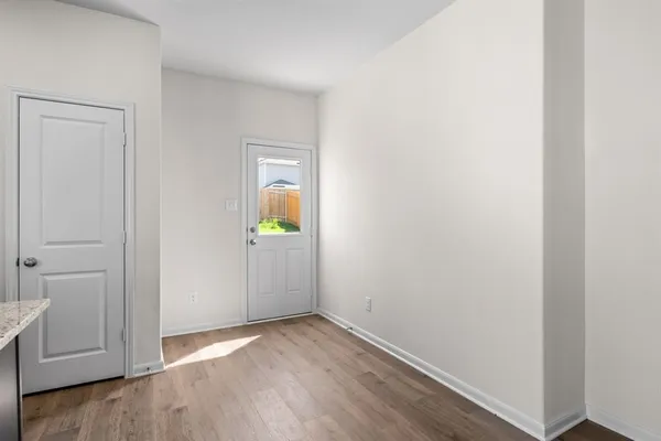 a view of empty room with wooden floor
