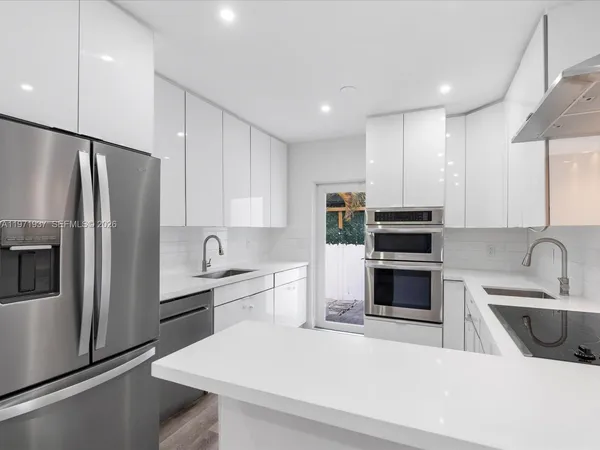 a kitchen with stainless steel appliances a refrigerator sink and microwave