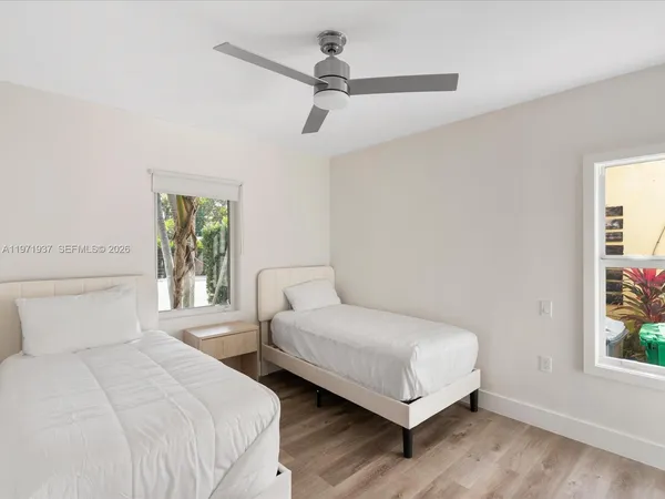 a bedroom with two beds and a window