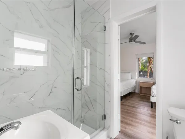 a bathroom with a sink a toilet and shower