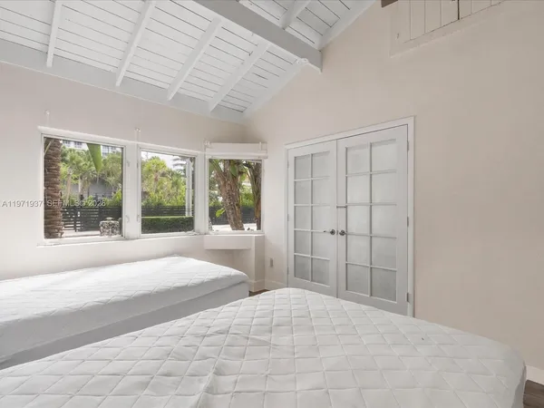 a large bed sitting in a spacious bedroom next to a window