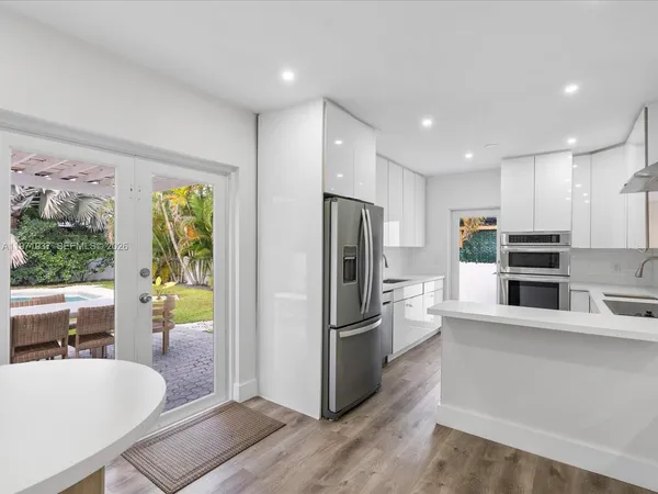 a kitchen with stainless steel appliances granite countertop a refrigerator and a stove top oven