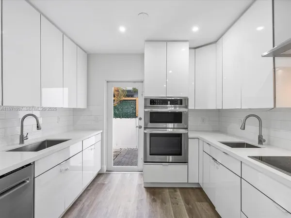 a kitchen with stainless steel appliances granite countertop a sink and a stove top oven