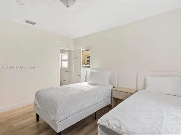 a bedroom with two beds and a night stand