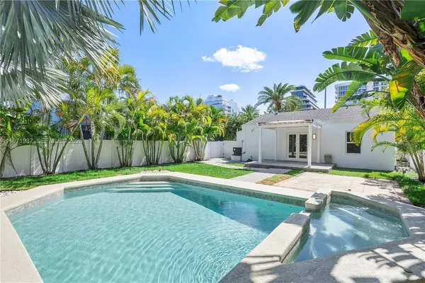 a view of a house with swimming pool and sitting area